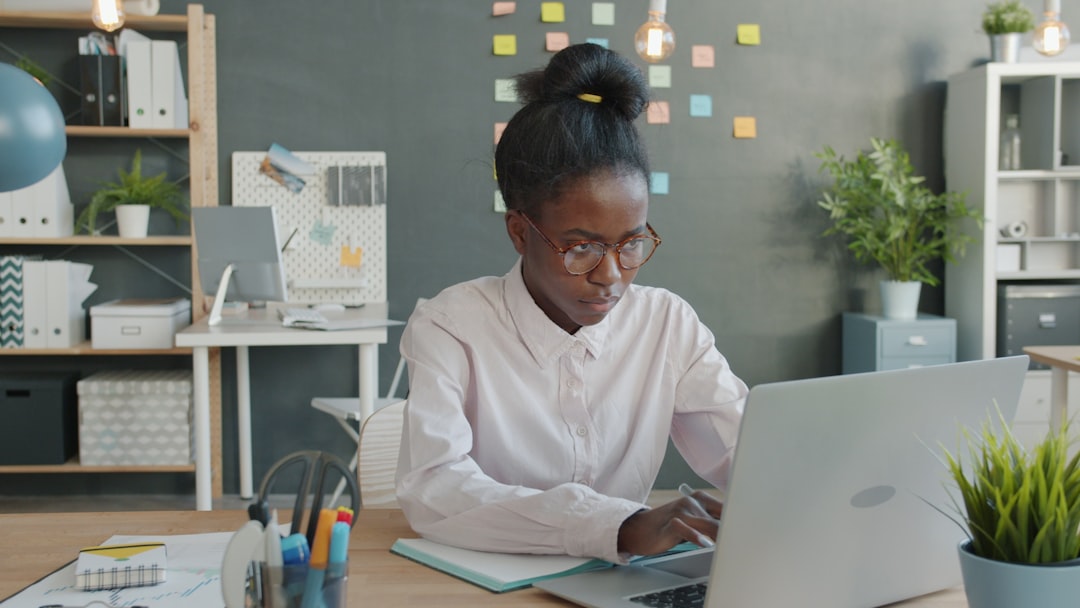 Young woman working on a laptop at a desk.