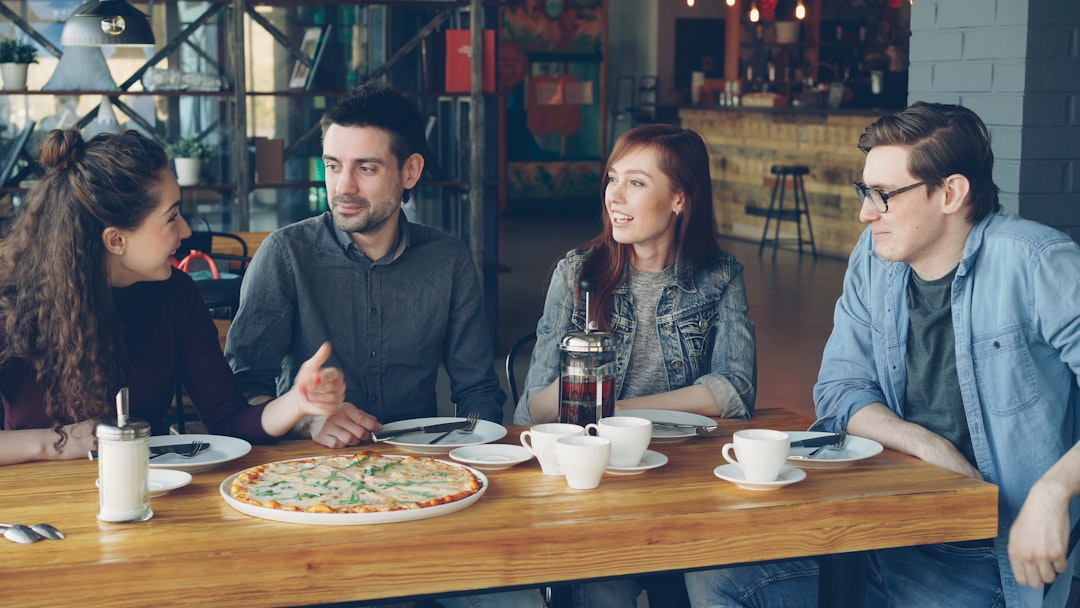 Friends enjoy pizza and conversation in a restaurant.