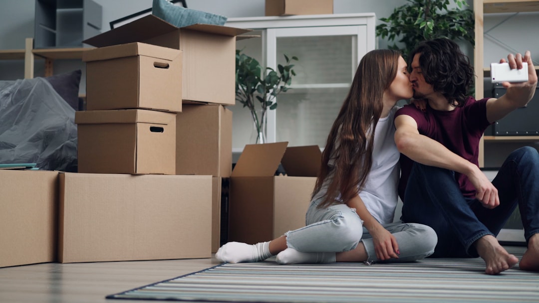a man and woman sitting on the floor kissing