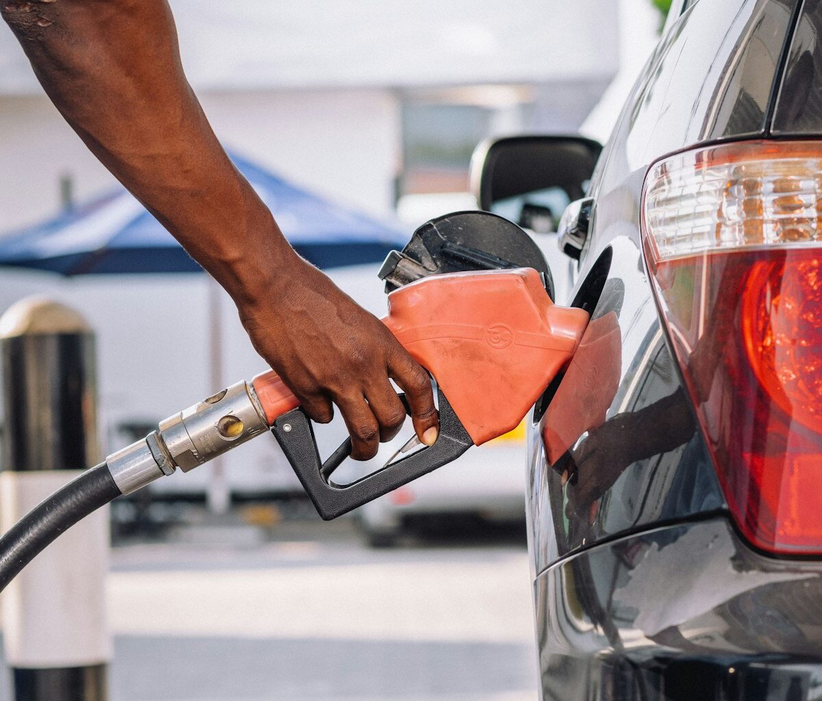 Tankpistool in de tankopening van een kleine auto bij een tankstation