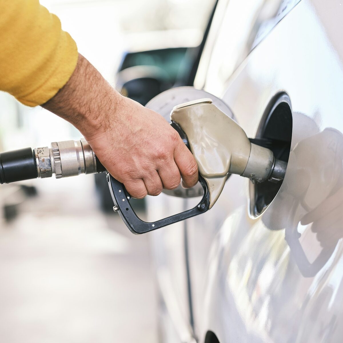 Tankpistool in de vulopening van een auto bij een tankstation