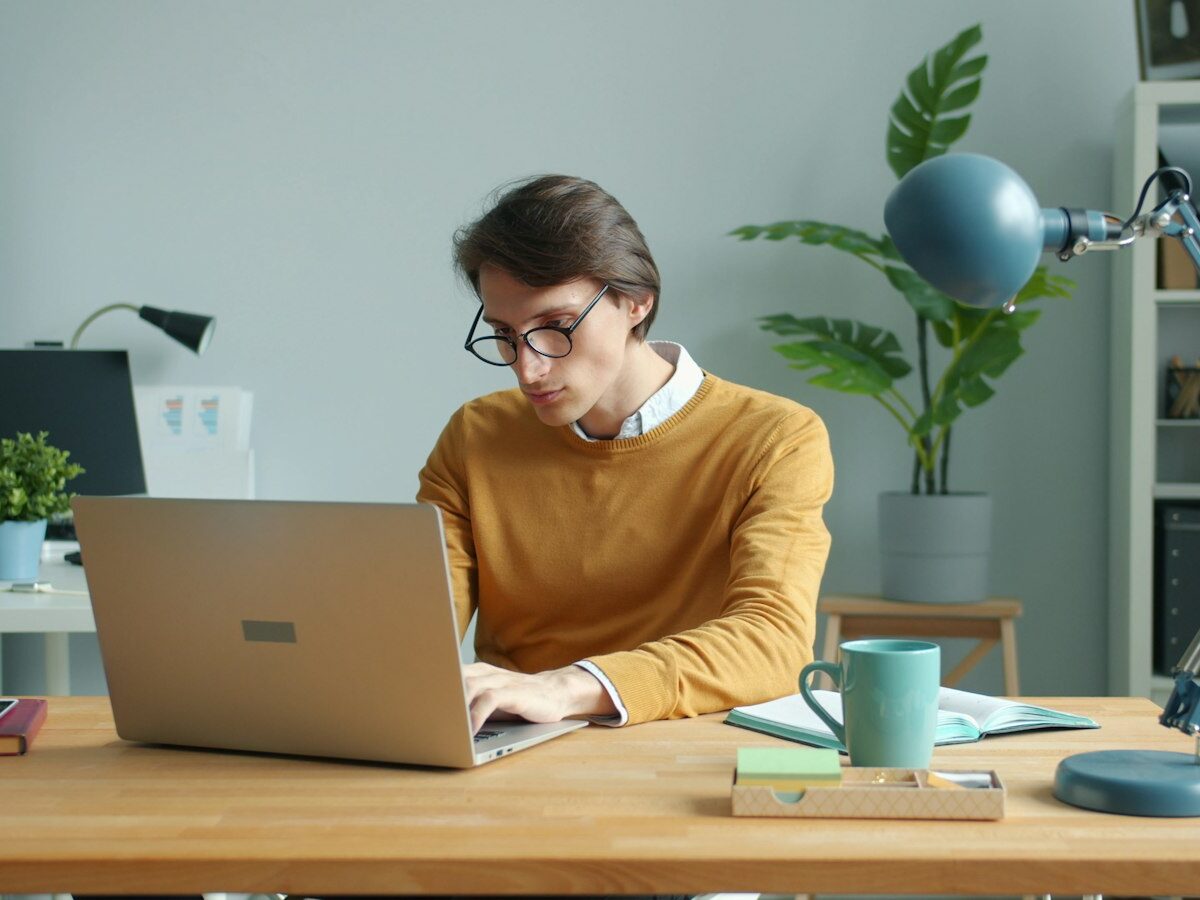 Starter werkt aan een laptop aan een bureau met een notitieboek