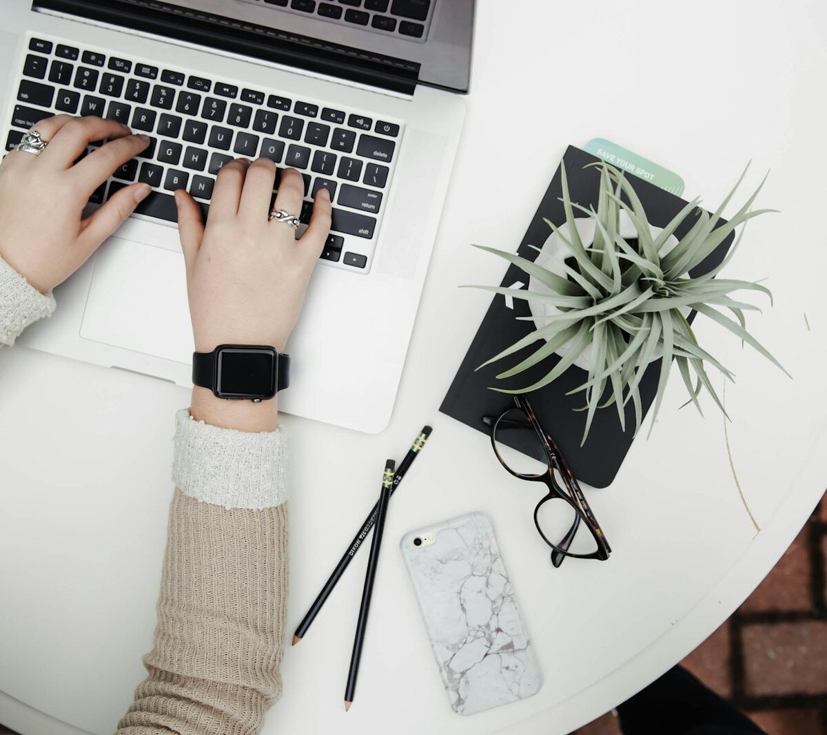 Iemand schrijft een brief aan een bureau met een laptop en koffie