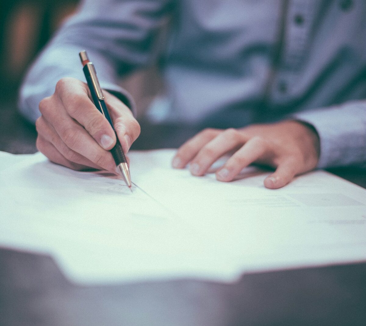 Jonge werknemer ondertekent een arbeidscontract aan een bureau