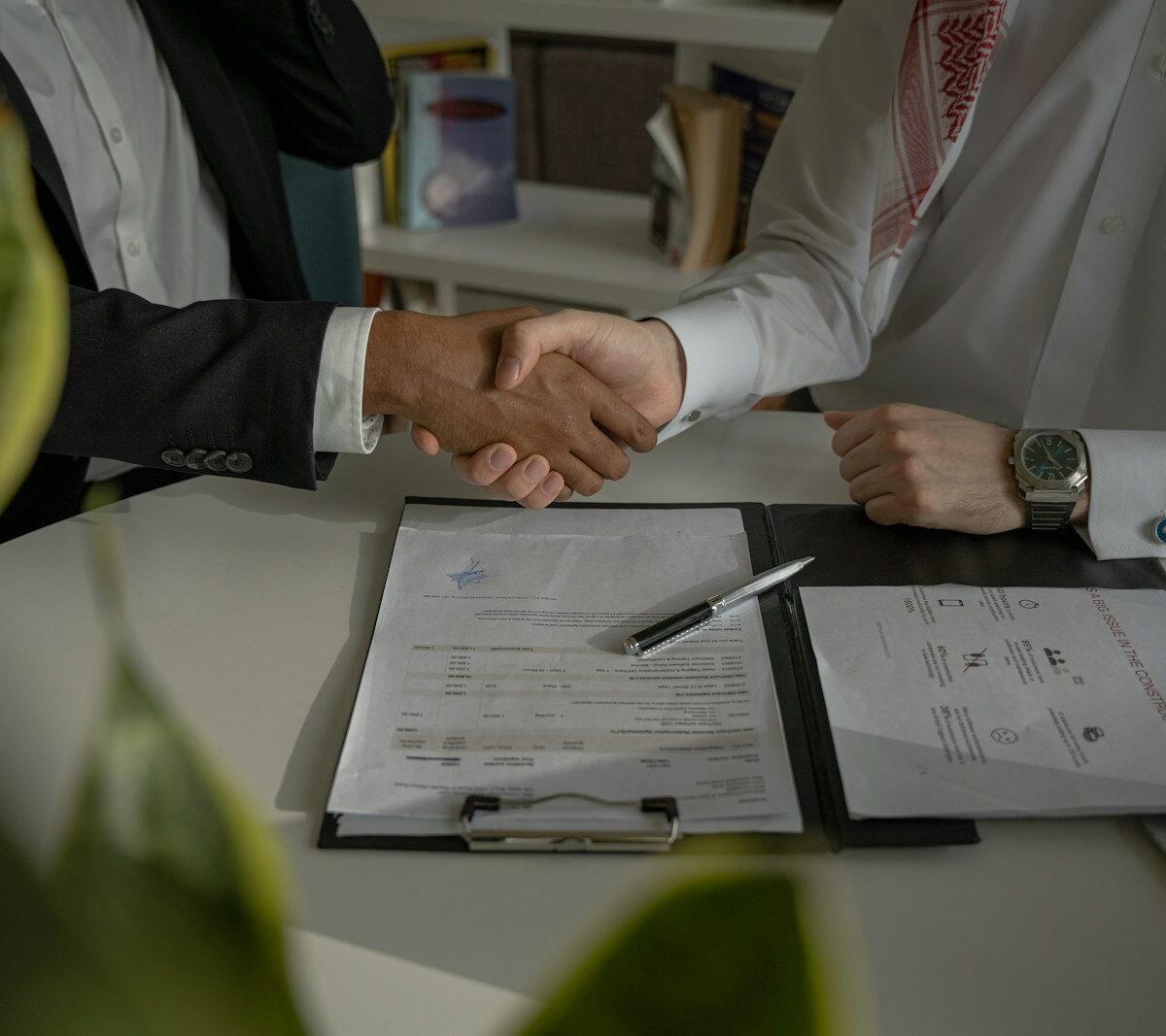 Jonge werknemer in gesprek met leidinggevende aan een tafel op kantoor