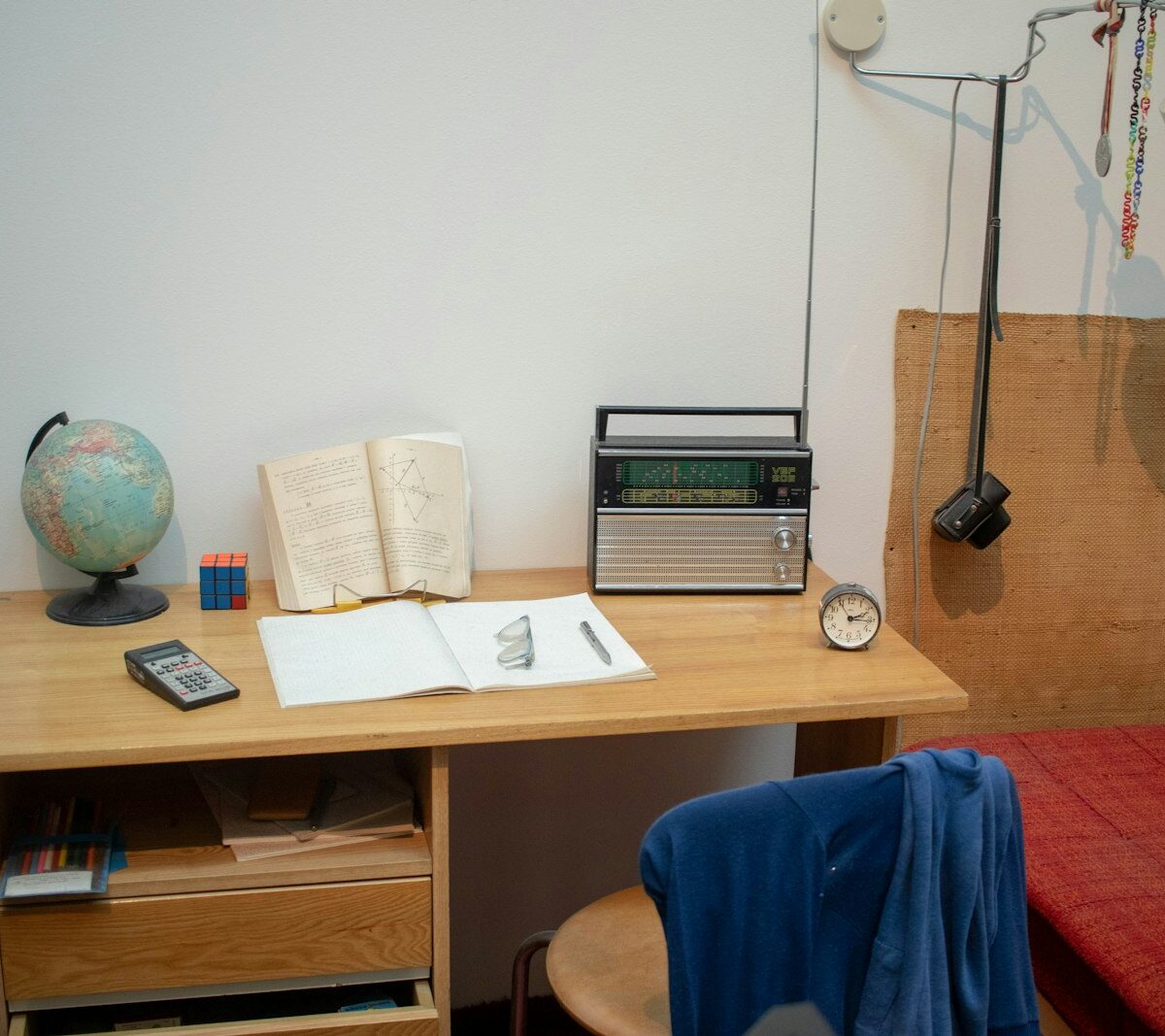 Studentenkamer met bureau, bed en verhuisdozen