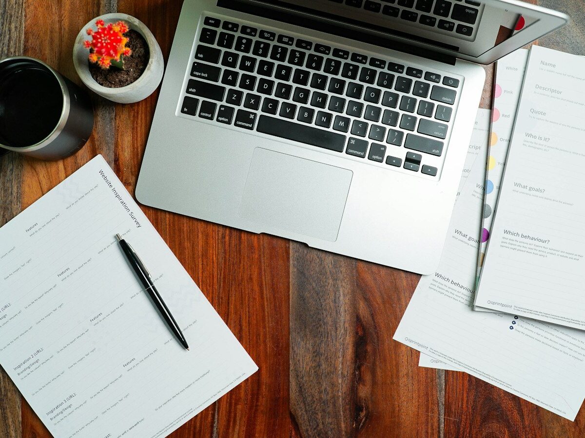 Student met laptop en papieren aan een bureau