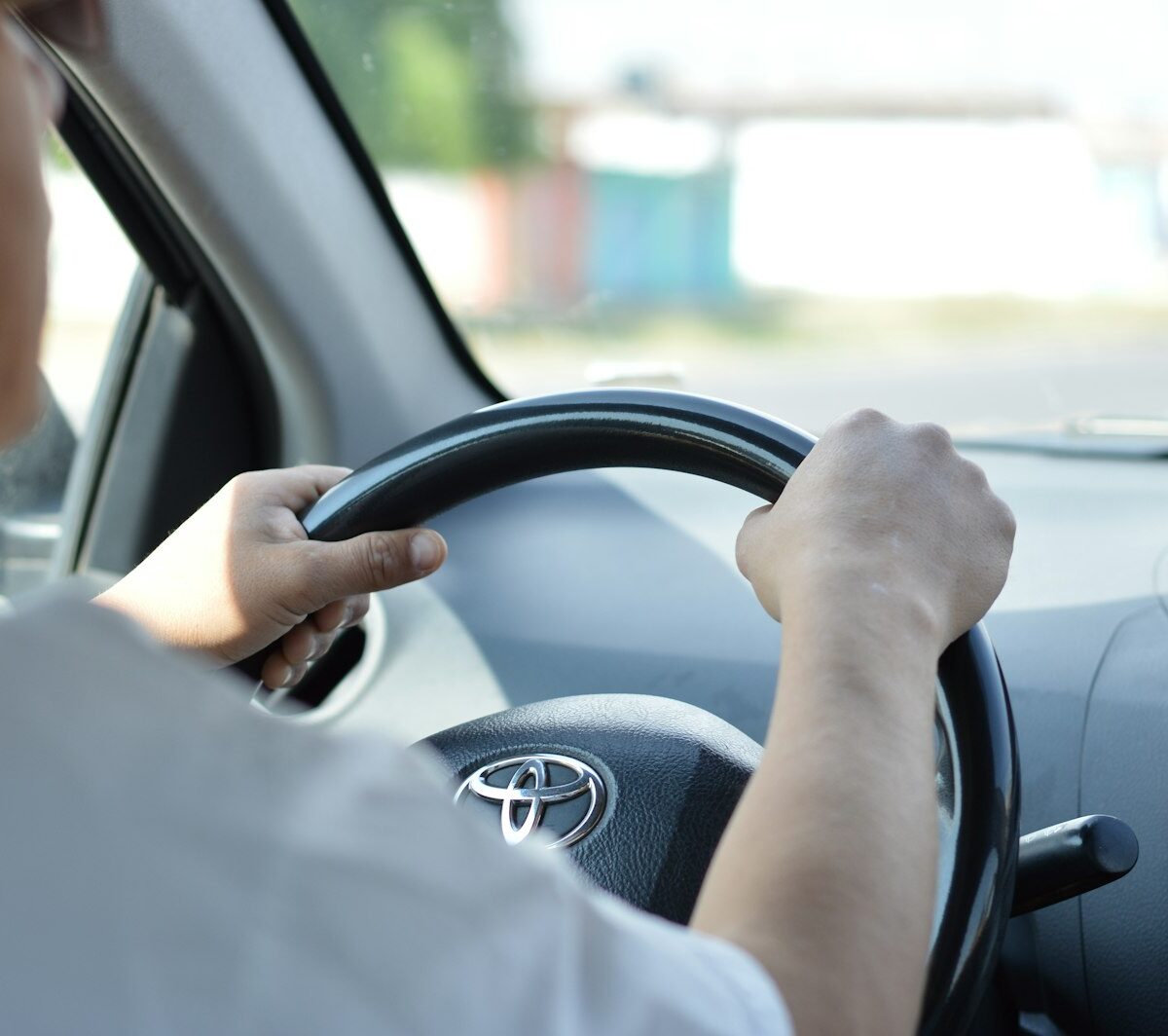Jonge bestuurder achter het stuur van een tweedehands auto