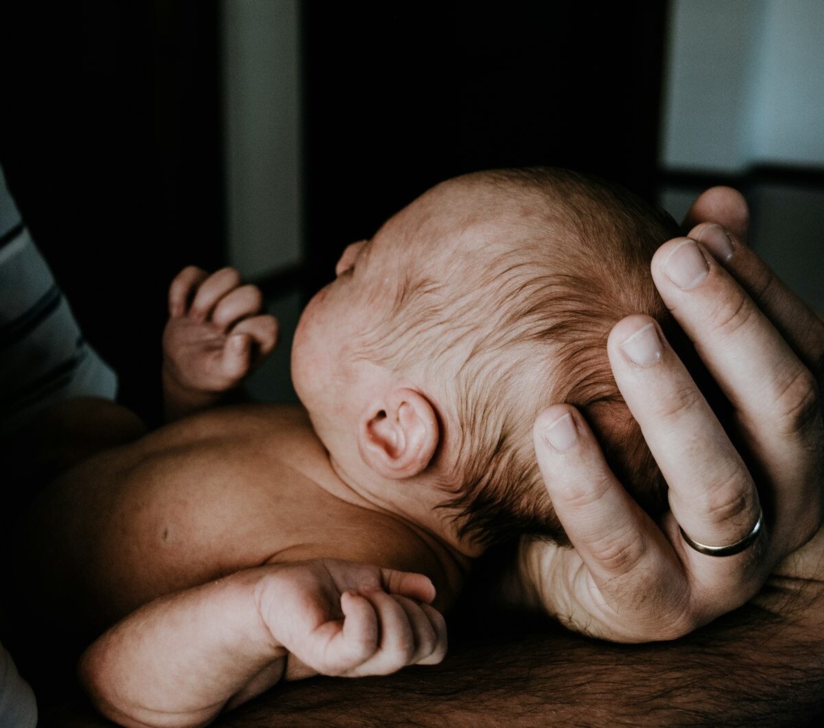 Jonge vader houdt zijn pasgeboren baby vast in de woonkamer