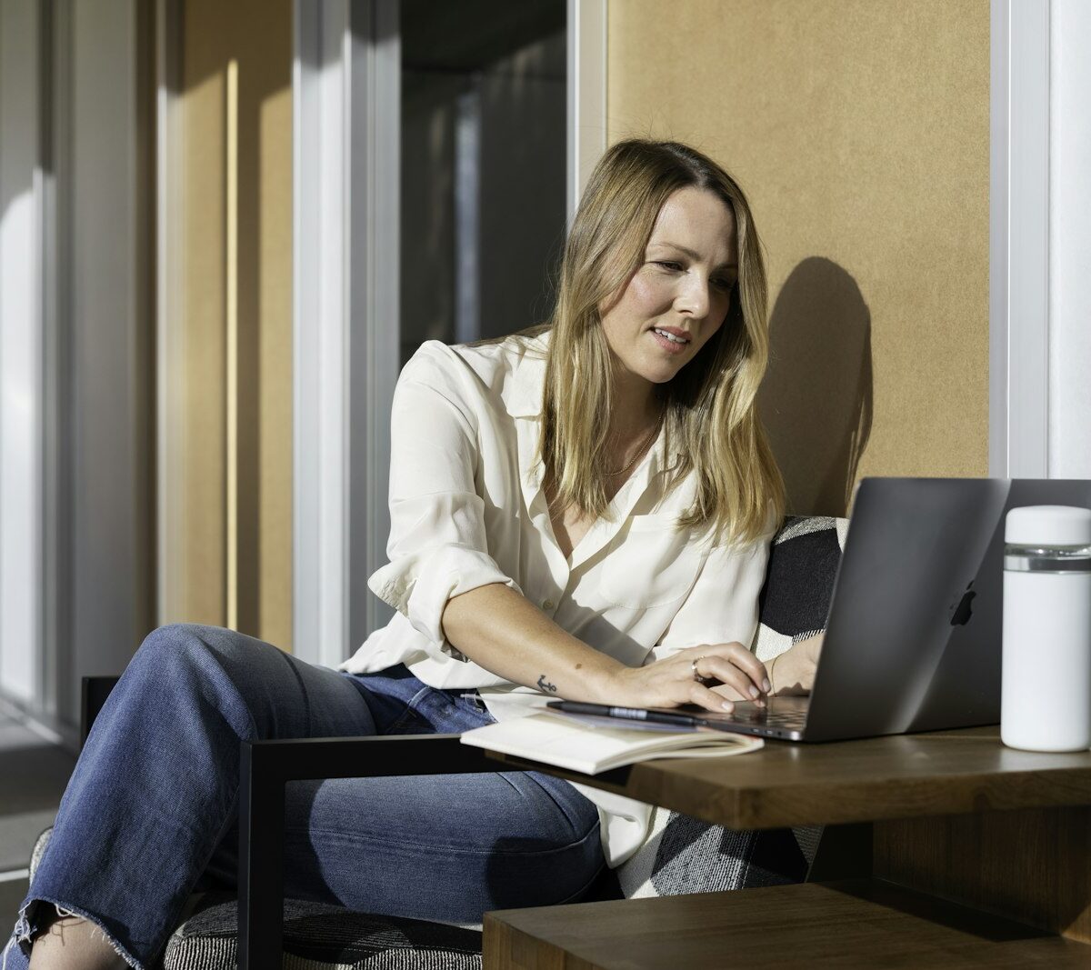 Jonge vrouw doet haar belastingaangifte op een laptop aan de keukentafel