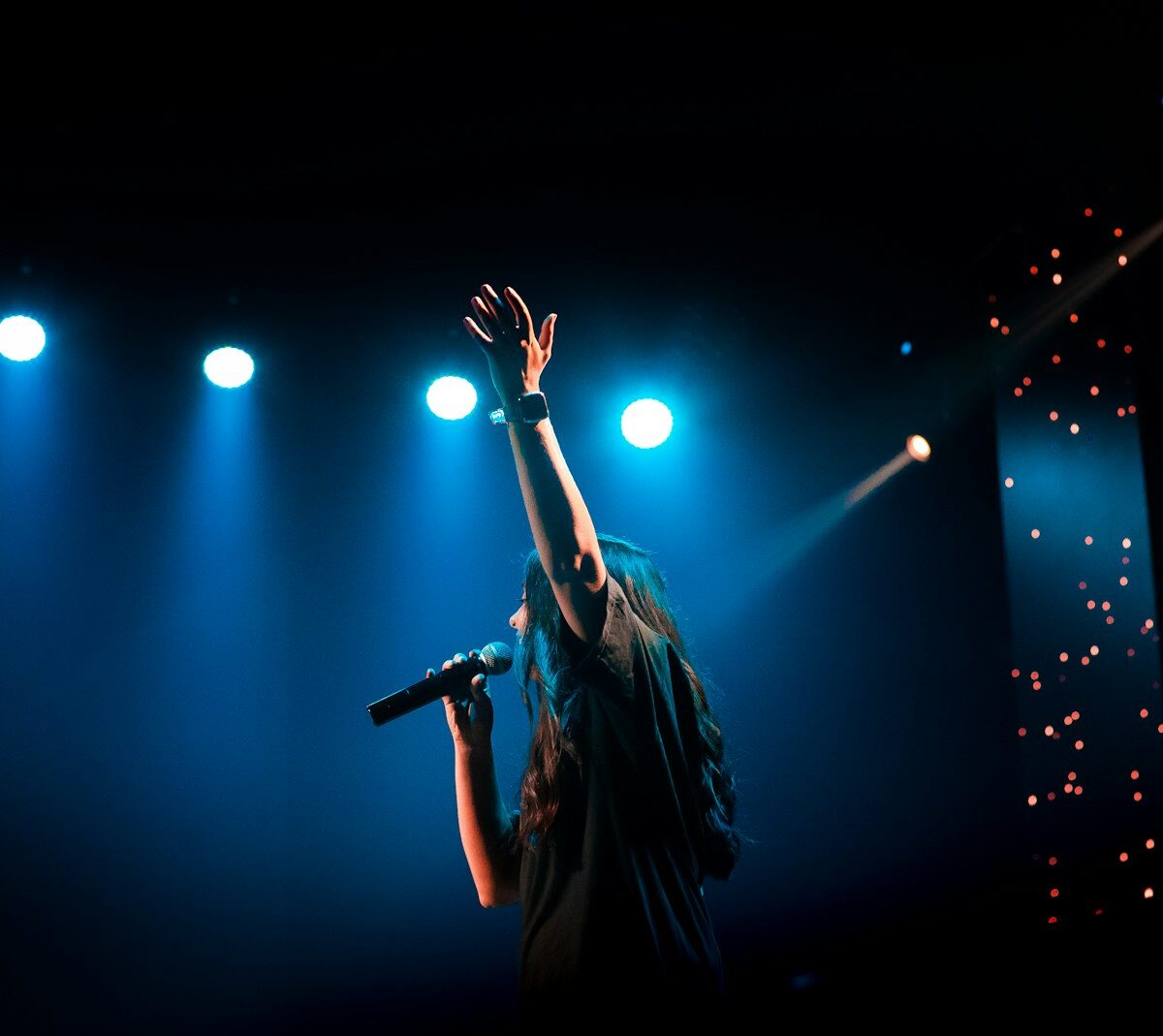 Zangeres op een podium tijdens een concert met band en lichtshow