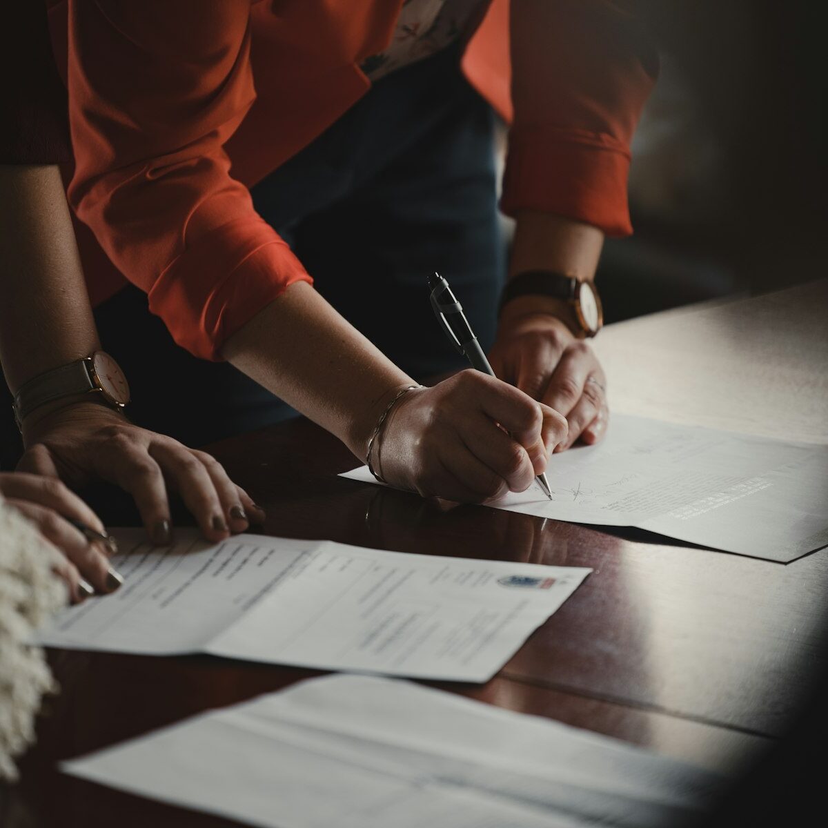 Ouder en volwassen kind tekenen samen een document aan tafel
