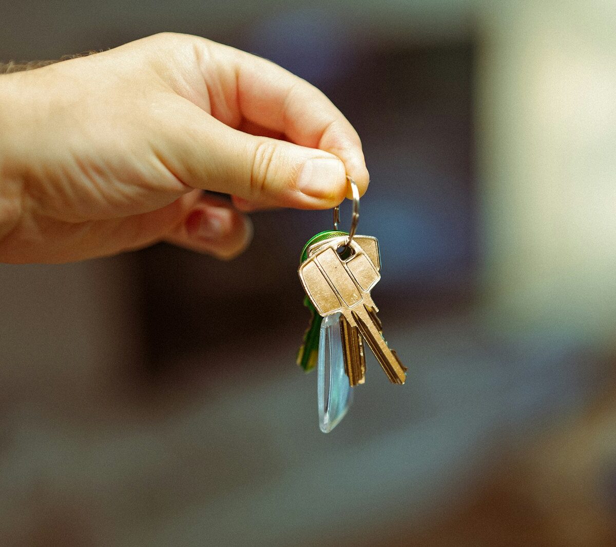 Jong stel met de sleutels van hun eerste huis voor de voordeur