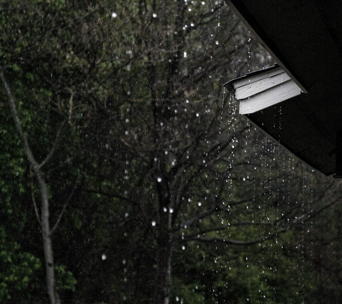 Regenpijp en dakgoot van een rijtjeshuis tijdens regen