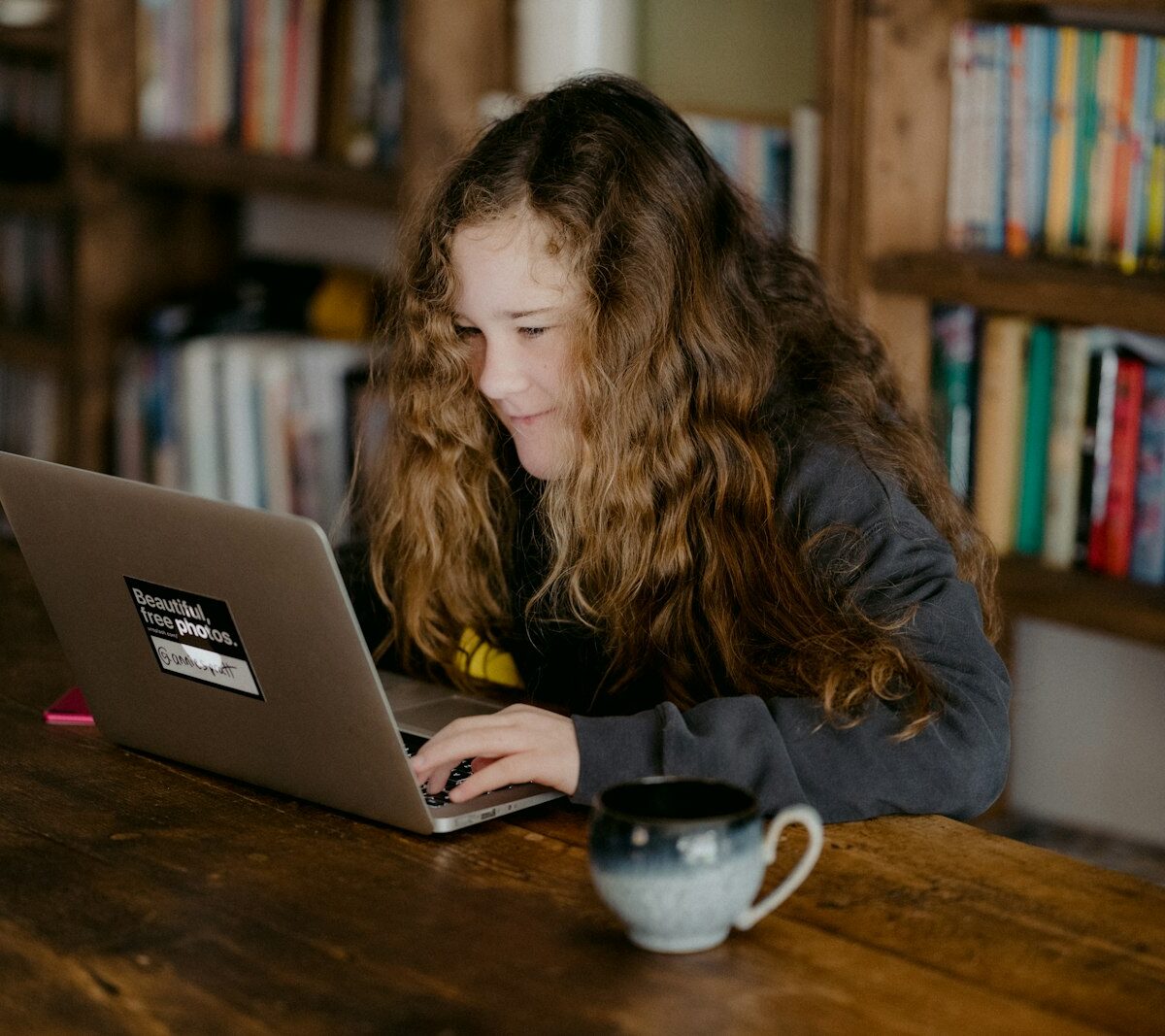 Student met laptop en studieboeken aan een bureau
