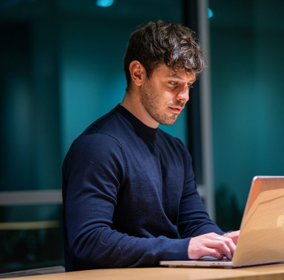 Jongvolwassene vergelijkt zorgverzekeringen op een laptop aan de keukentafel